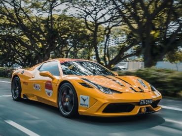 並木道を疾走する黄色いスポーツカー