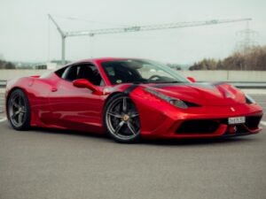 屋外のアスファルトの駐車場に駐車された赤いスポーツカー
